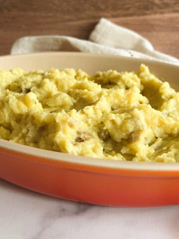 vegan instant pot mashed potatoes in a shallow orange serving dish