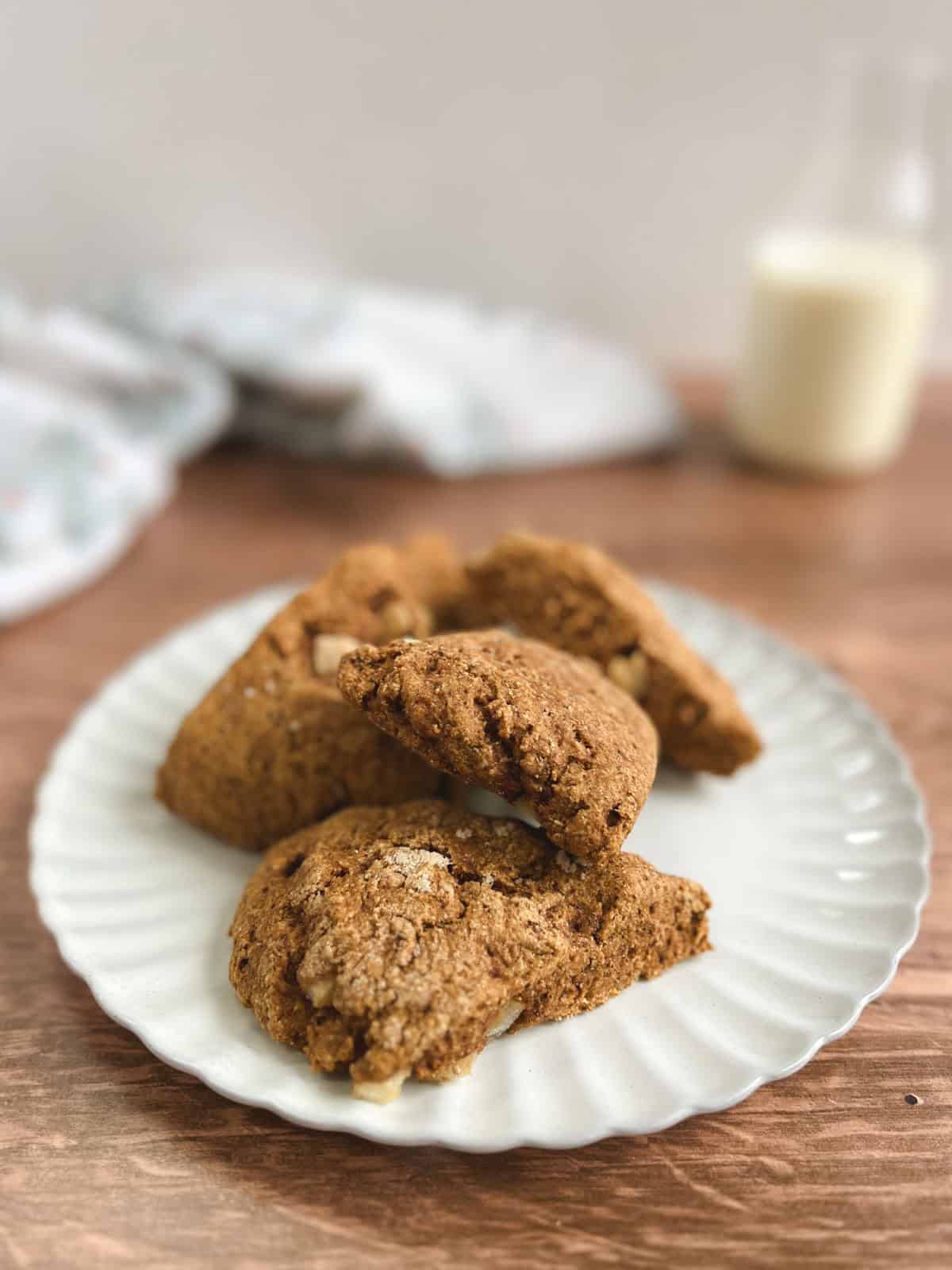 closeup of plate of ginger pear scones with a towel and glass bottle of milk blurred in the background