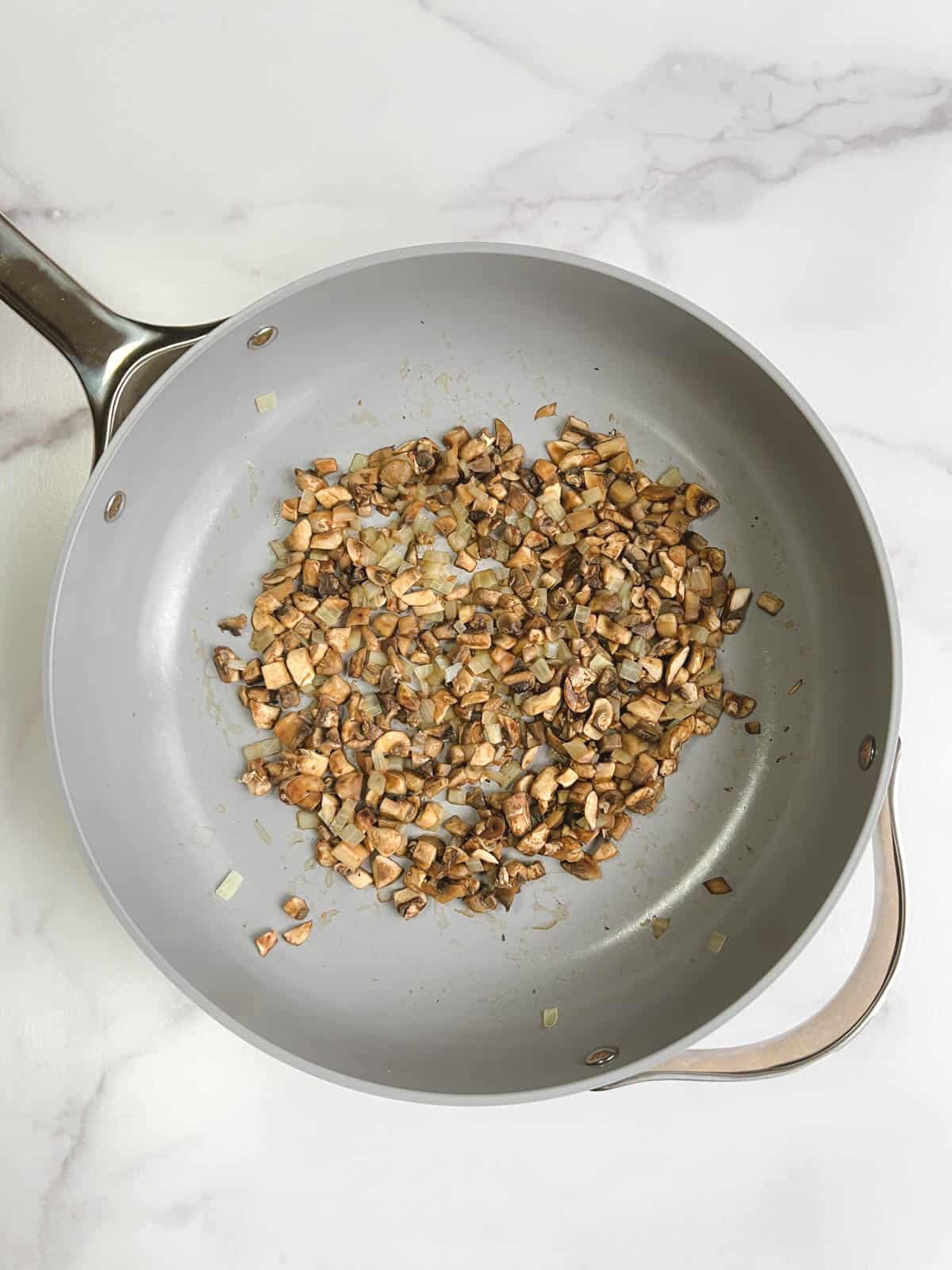 overhead view of skillet containing cooked onions and mushrooms