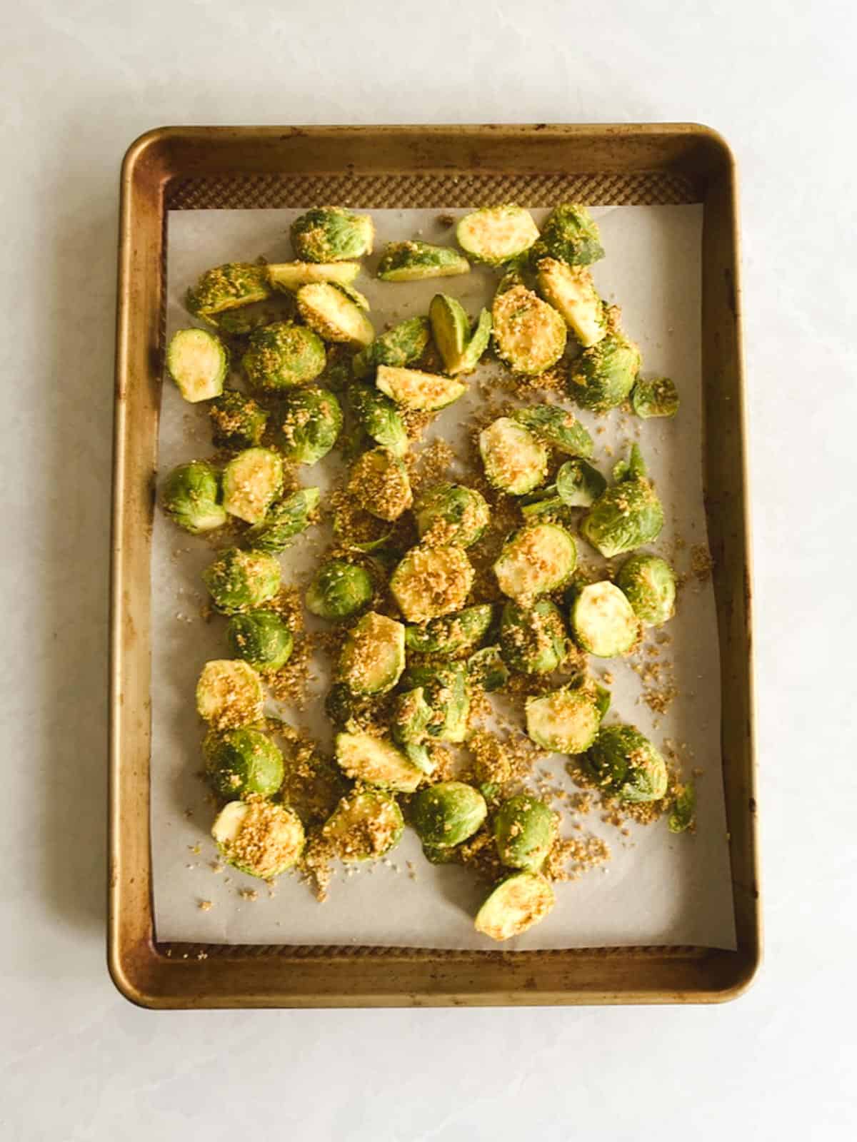 overhead view of prepared baking sheet with seasoned Brussels sprouts