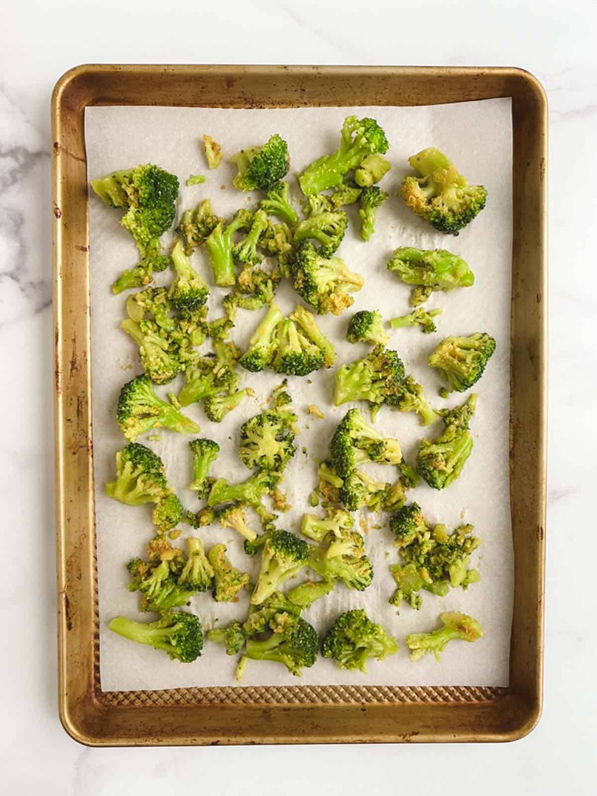 overhead view of prepared baking sheet containing uncooked broccoli