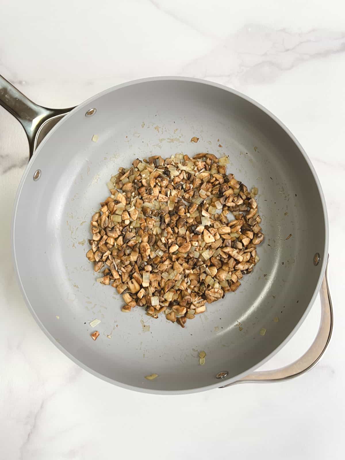 overhead view of skillet containing cooked mushrooms, onions, and garlic