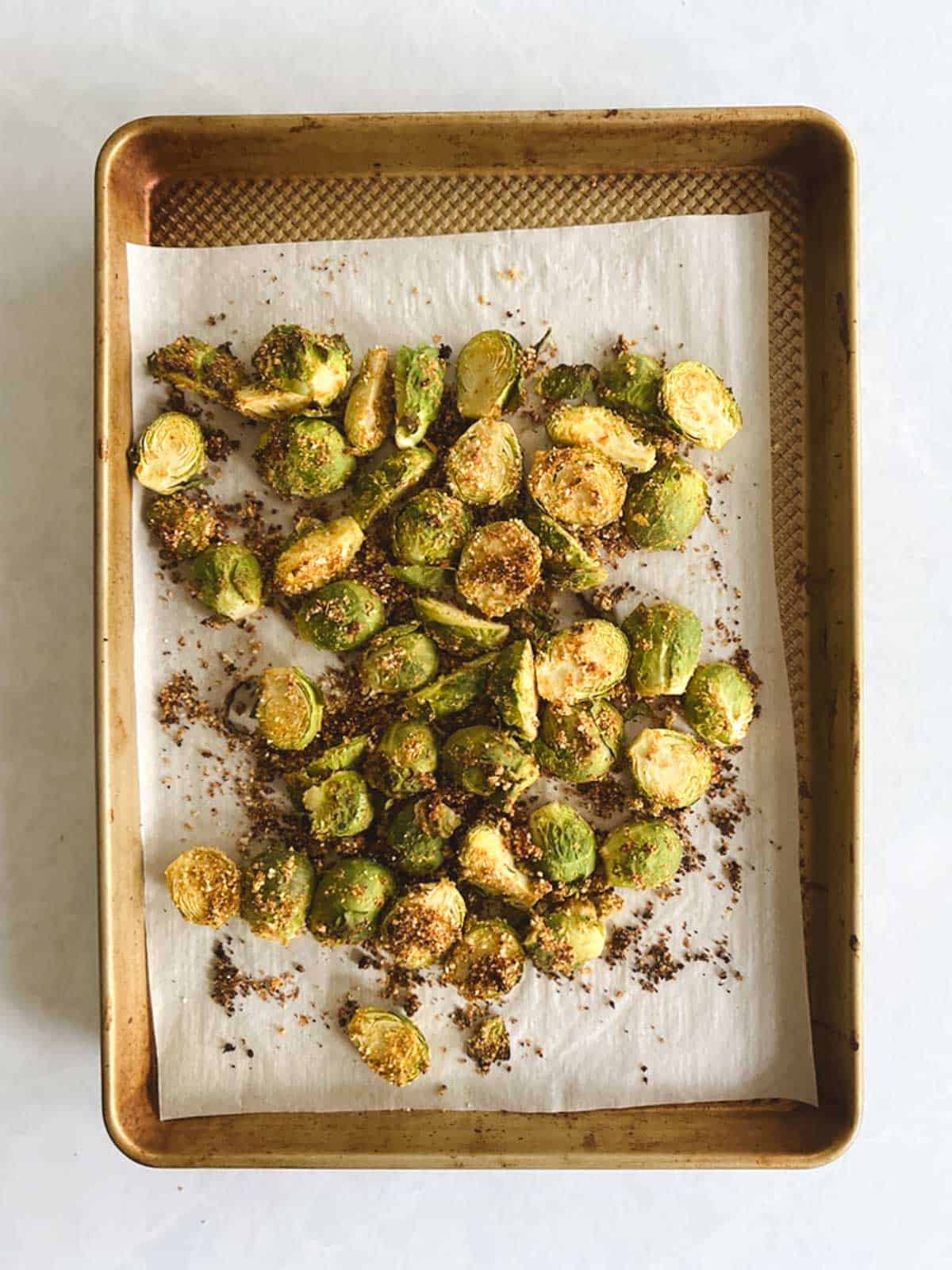 overhead view of prepared baking sheet with crispy Brussels sprouts after 15 minutes in the oven