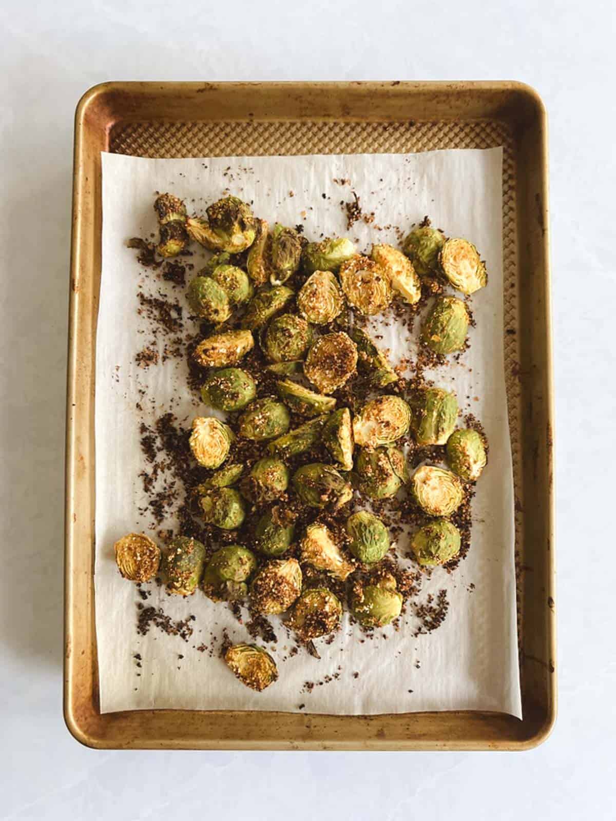 overhead view of prepared baking sheet with crispy Brussels sprouts roasted in the oven