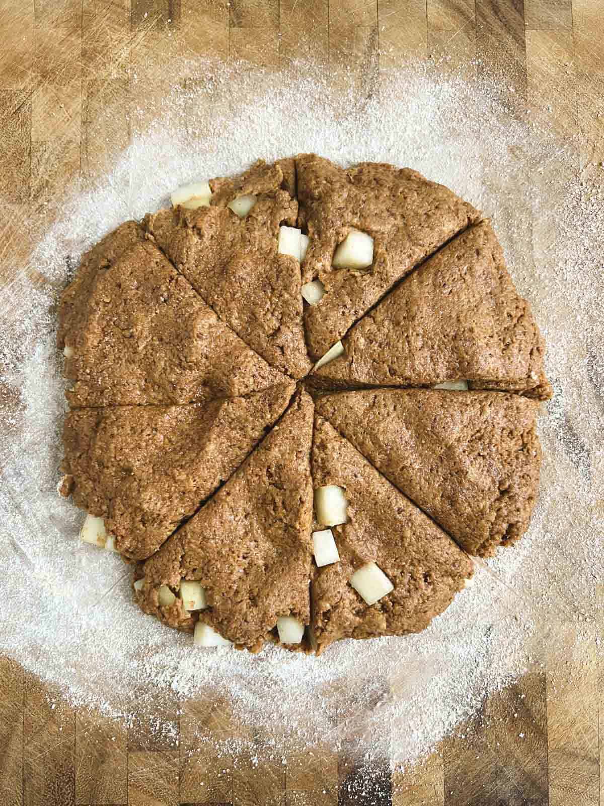 overhead view of lightly floured cutting board with circle of dough cut into 8 pieces