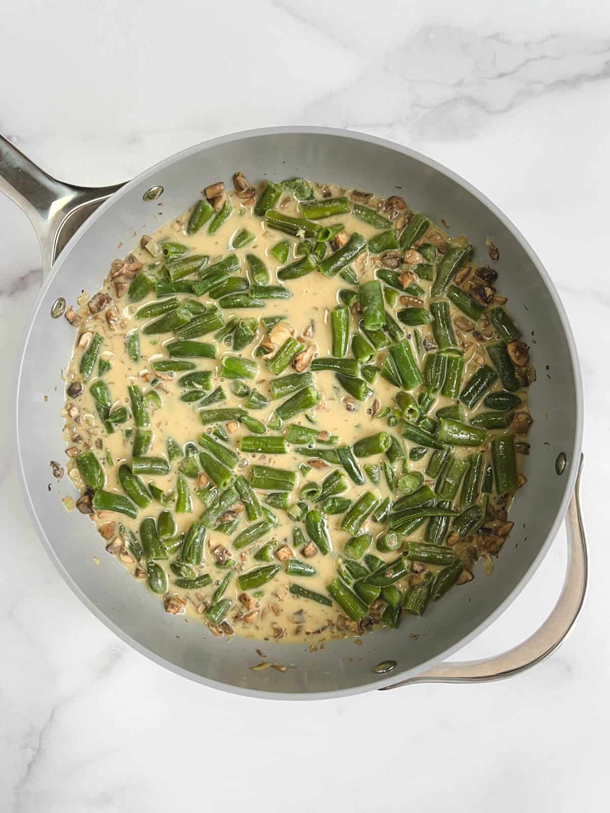 overhead view of skillet with green beans and rice vinegar added