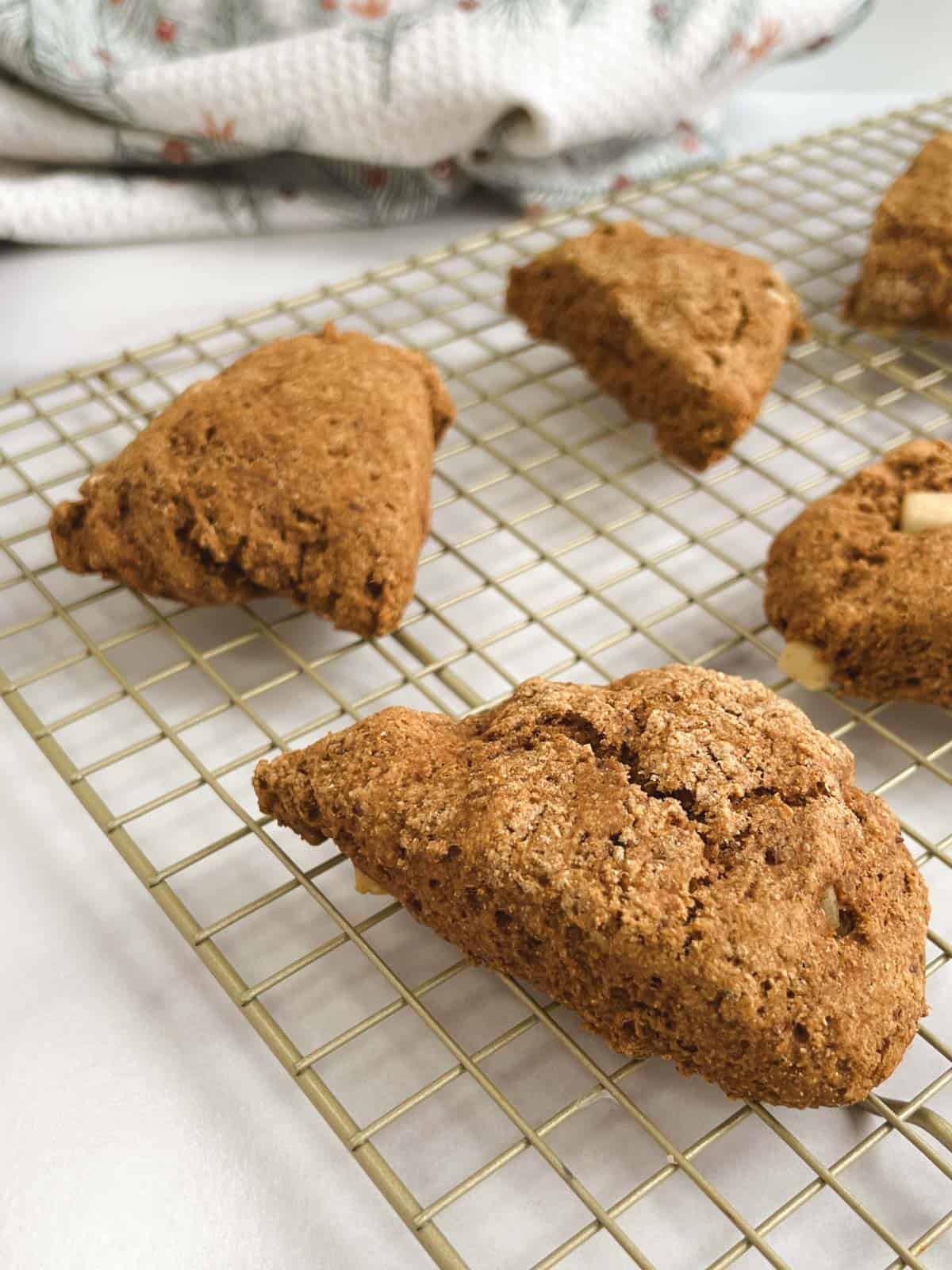 closeup of baked ginger pear scones cooling on a gold rack