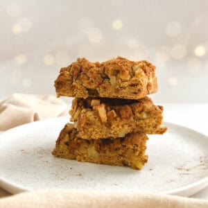 three squares of apple coffee cake stacked on a white plate