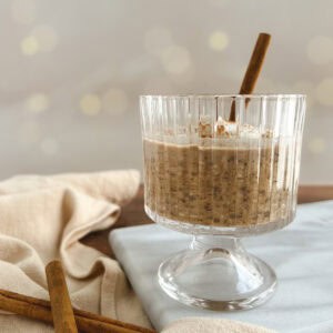 glass parfait cup of chai overnight oats with yogurt and cinnamon sticks