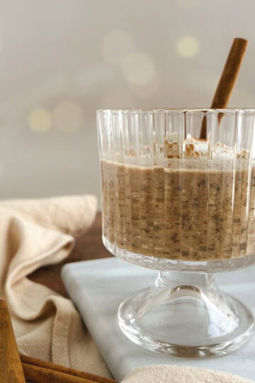 glass parfait cup of chai overnight oats with yogurt and cinnamon sticks