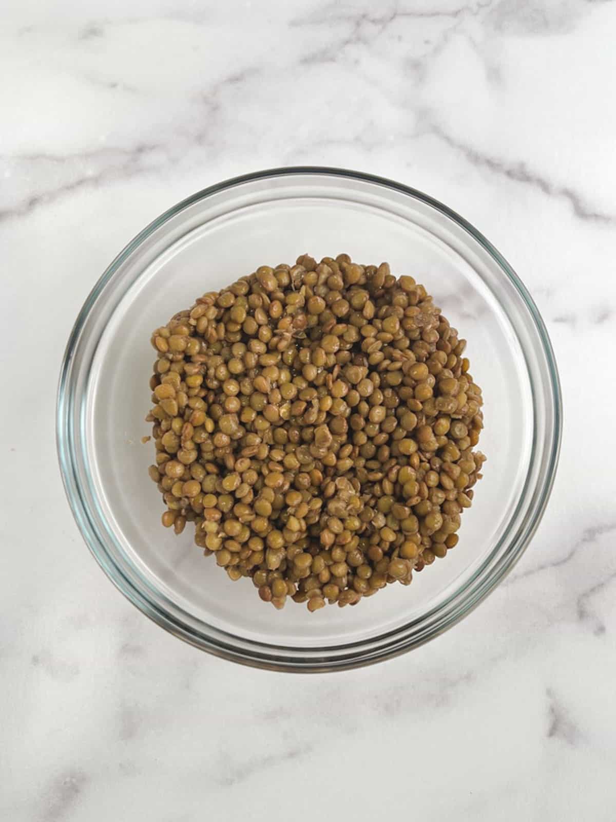 overhead view of glass bowl containing cooked lentils