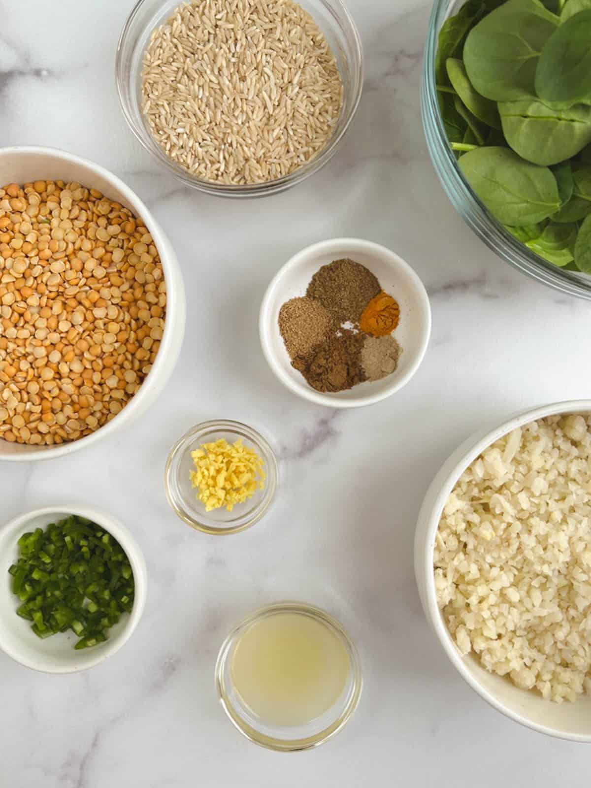 overhead view of bowls containing ingredients for Instant Pot kitchari on a marble background