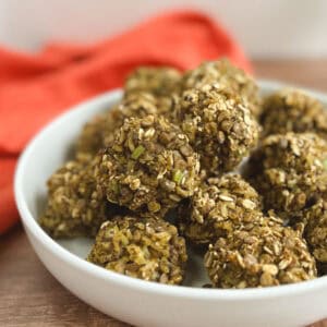 closeup of a white bowl of lentil meatballs with an orange napkin blurred in the background