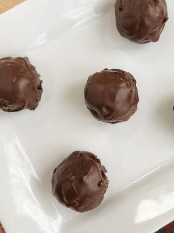 overhead of no bake chocolate peanut butter balls on a white rectangular serving dish