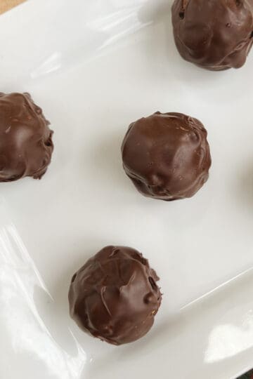 overhead of no bake chocolate peanut butter balls on a white rectangular serving dish