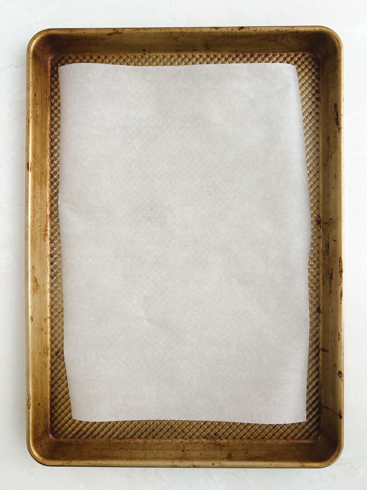 overhead view of gold baking sheet lined with parchment paper