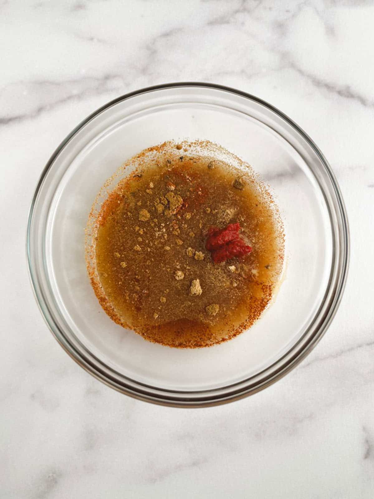 unmixed ingredients for sauce in a glass bowl on a marble background