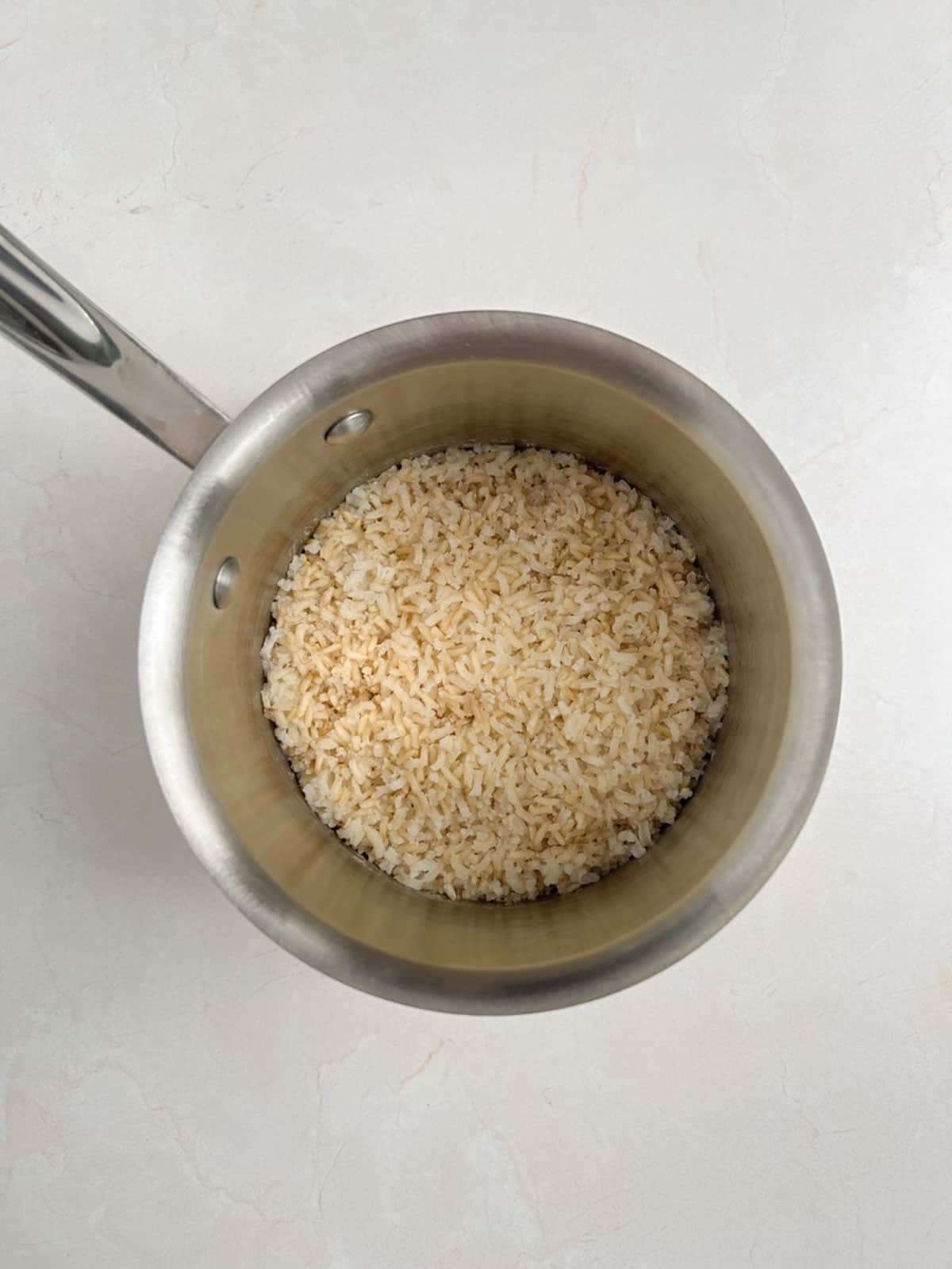 overhead view of small pot containing cooked brown rice