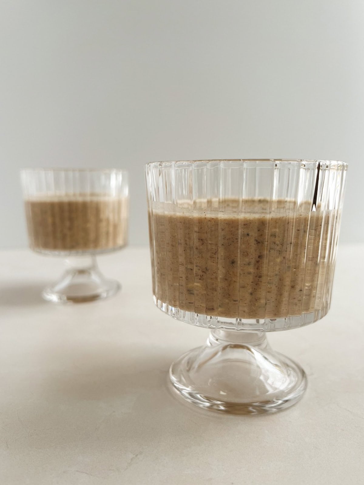 two parfait glasses containing chai overnight oats