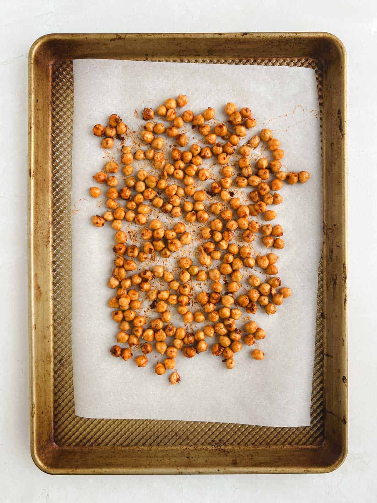 overhead view of prepared baking sheet containing harissa-coated chickpeas