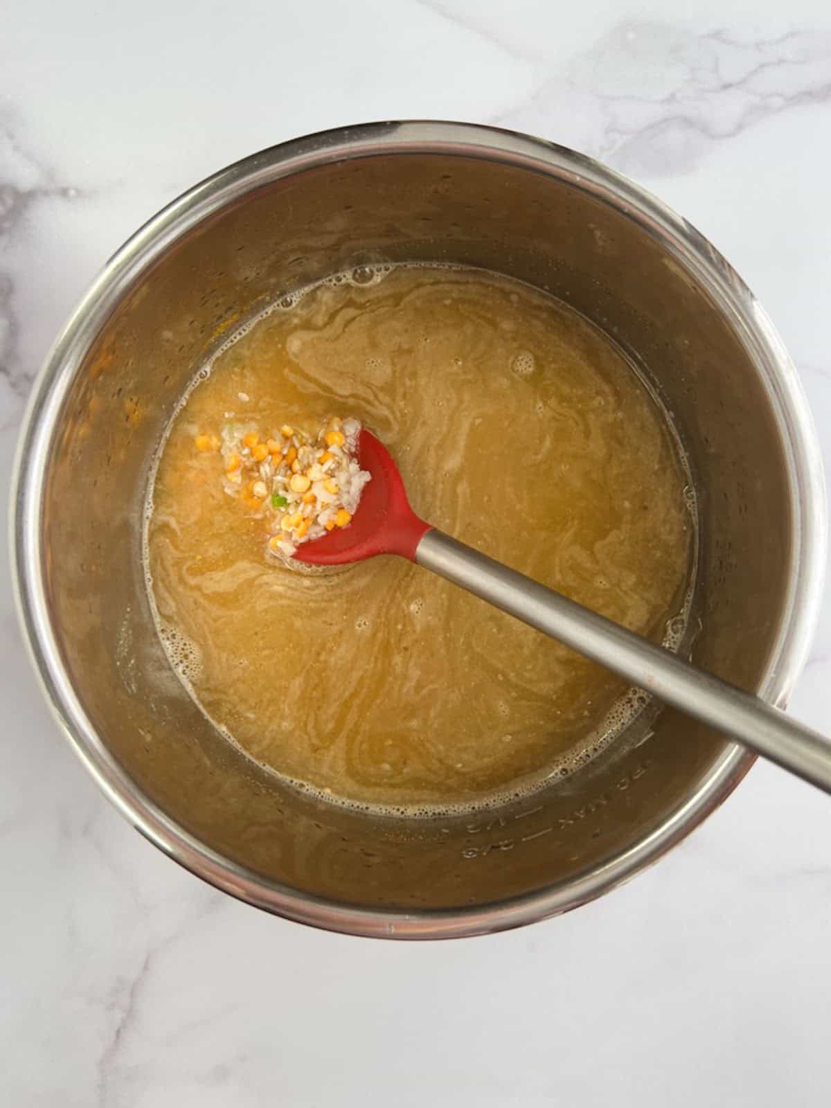 overhead view of Instant Pot inner pot containing all ingredients except lemon juice and spinach