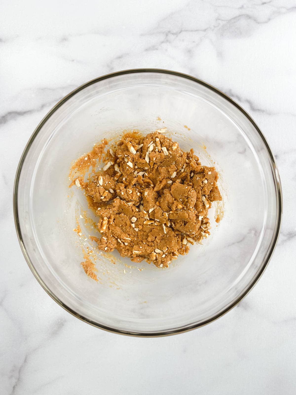 overhead view of glass bowl containing combined ingredients for no bake chocolate peanut butter balls