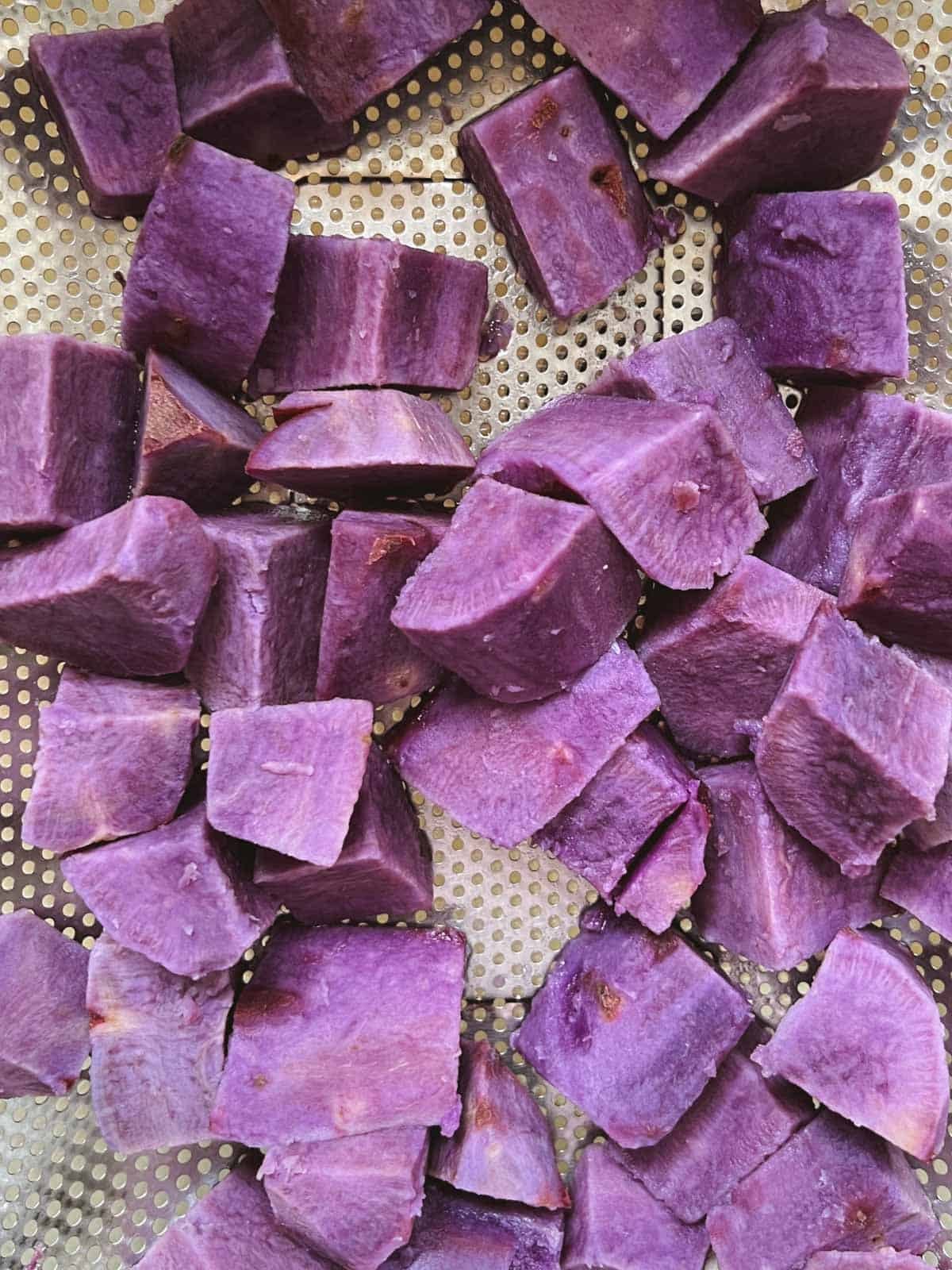 closeup of diced purple potatoes draining in a colander