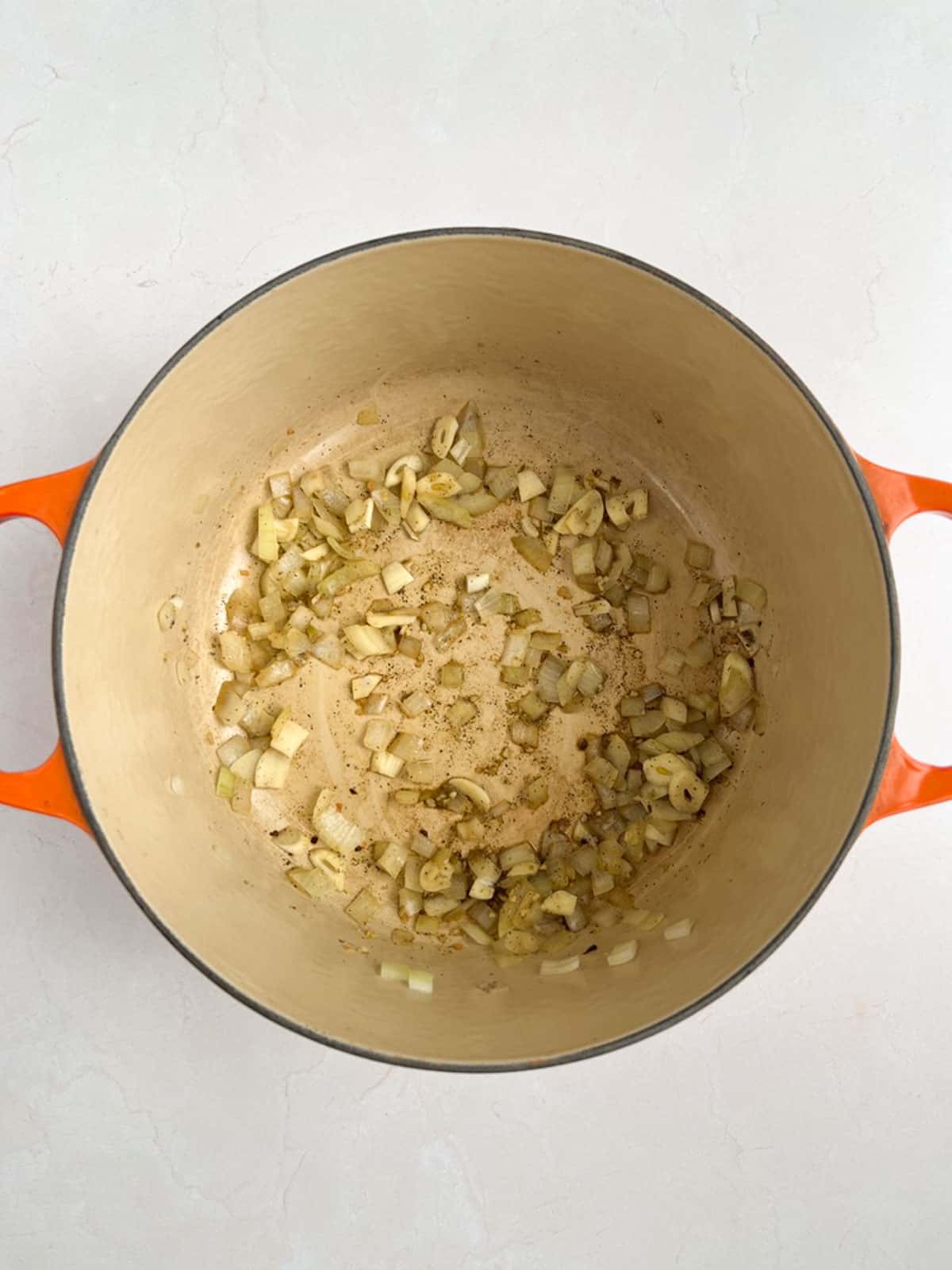 overhead view of Dutch oven containing cooked onions and garlic