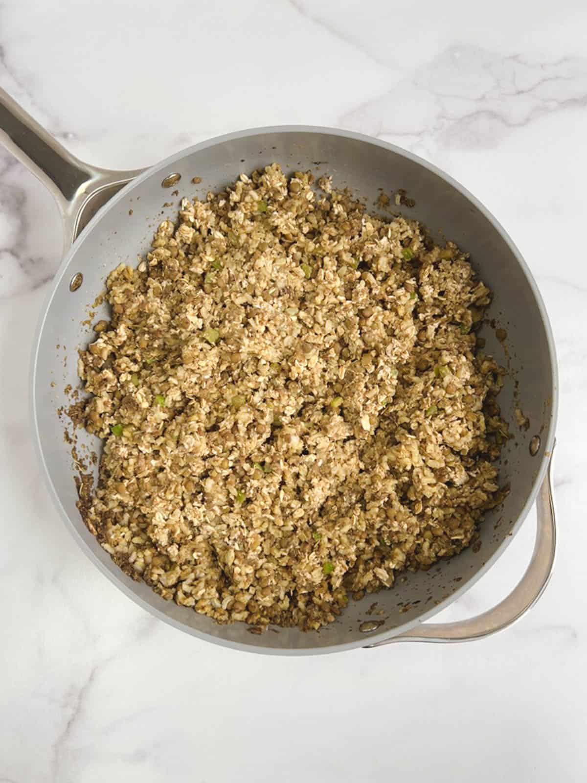 overhead view of sauté pan with broth-oat mixture added