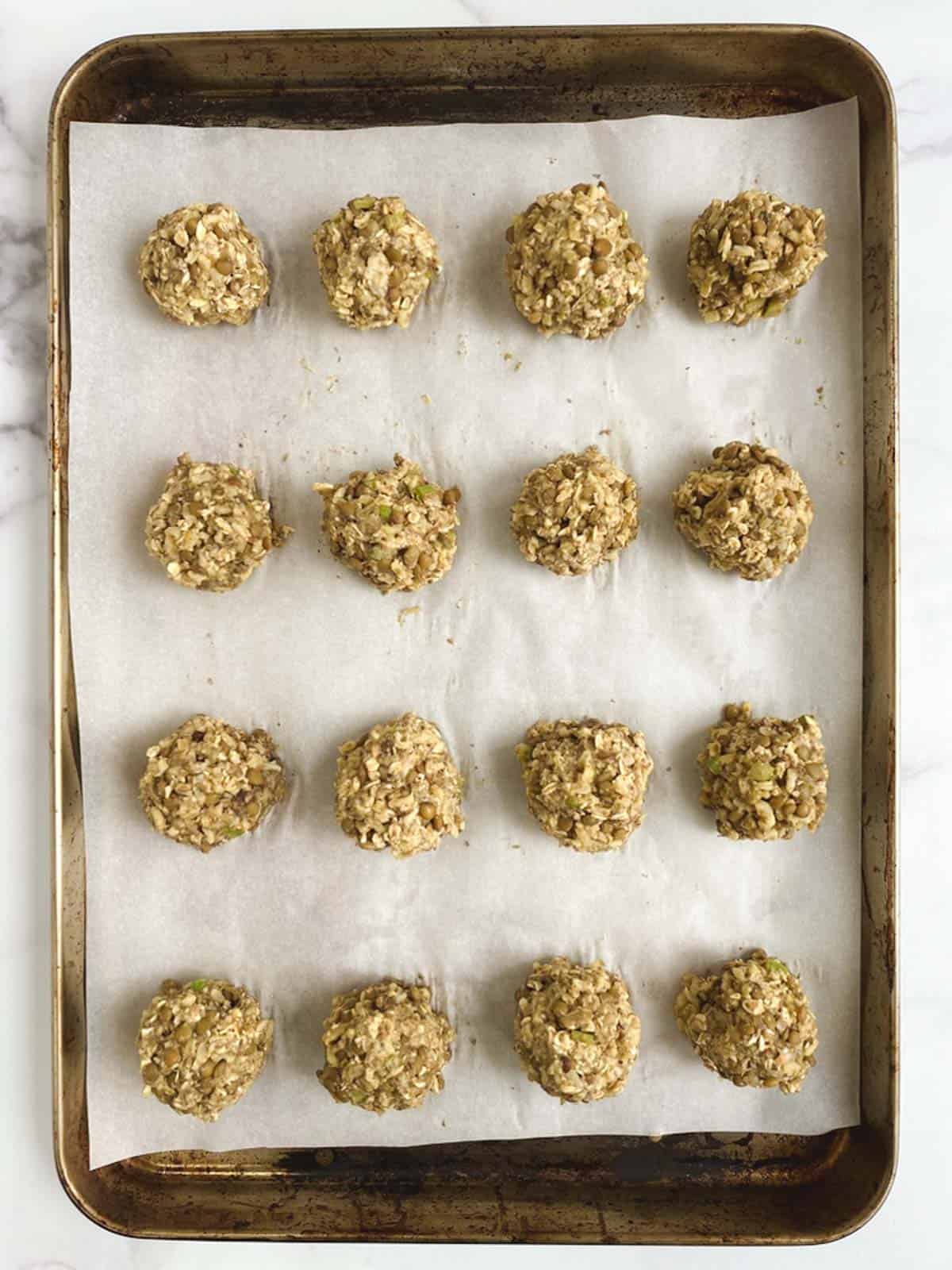 overhead view of prepared baking sheet containing 12 lentil meatballs