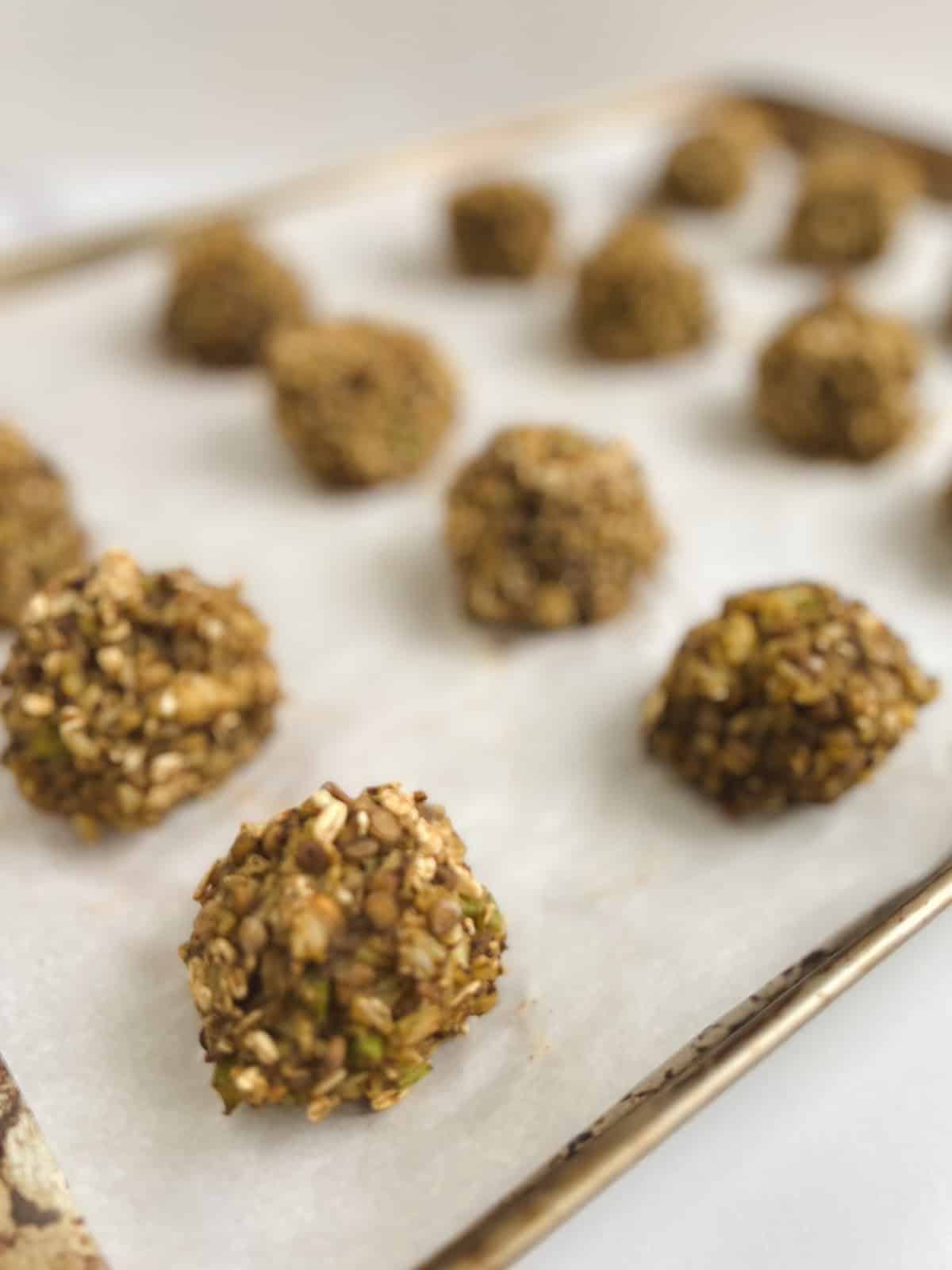 closeup of baked lentil meatballs on prepared baking sheet