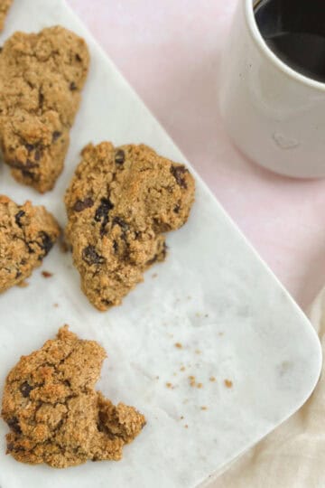 chocolate cherry scones on a marble serving tray next to a cup of coffee