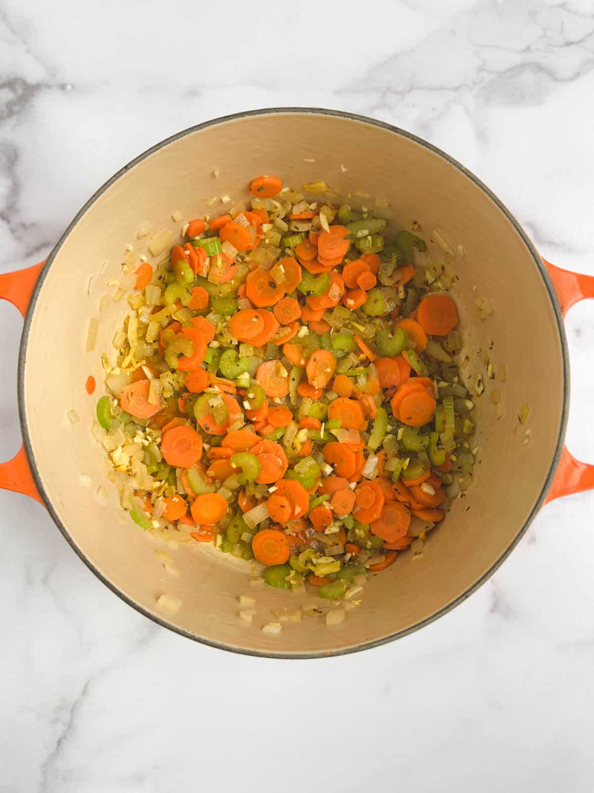 overhead view of Dutch oven containing cooked vegetables with seasoning added