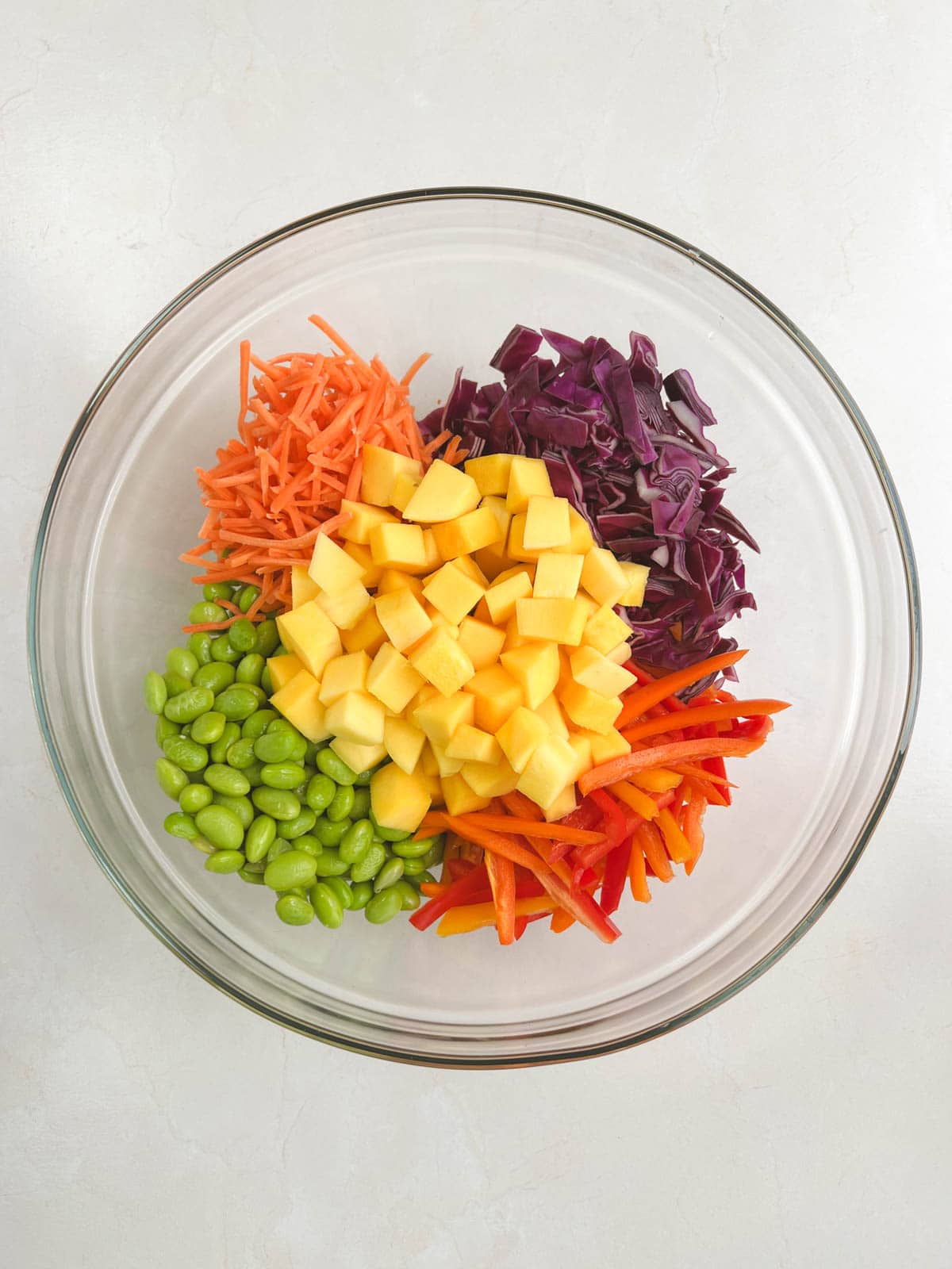 ingredients for mango noodle salad in a glass bowl