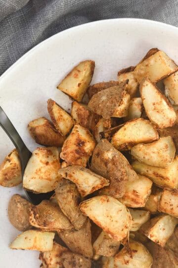 oil-free roasted potatoes in a bowl next to a gray linen napkin