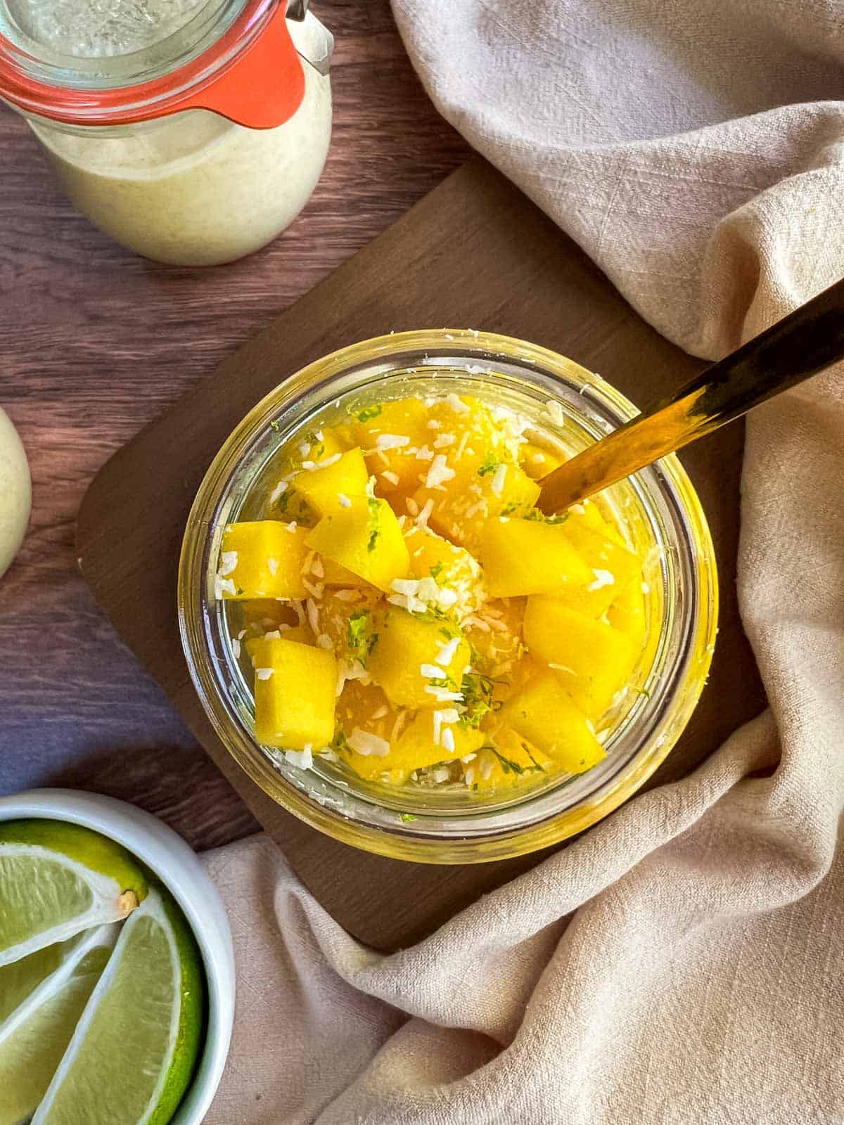 Glass jar of mango overnight oats with topping