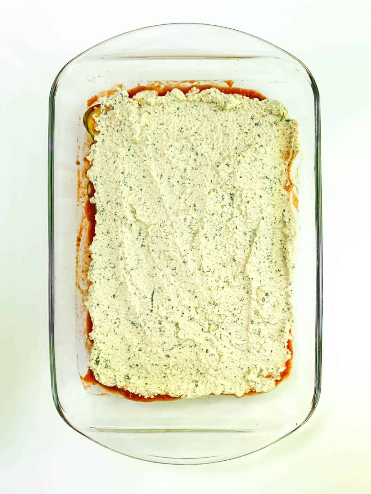 A casserole dish with whipped basil ricotta in it