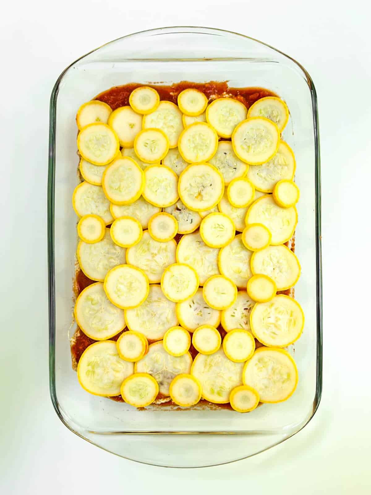 A casserole dish filled with sliced yellow squash