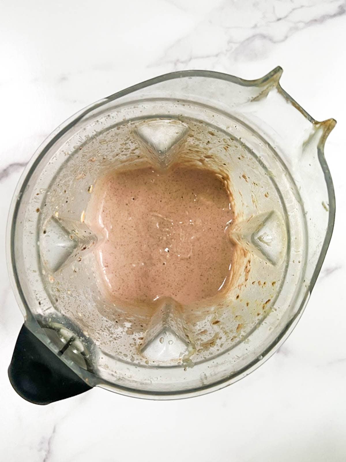 A blender filled with blended strawberry overnight oats.