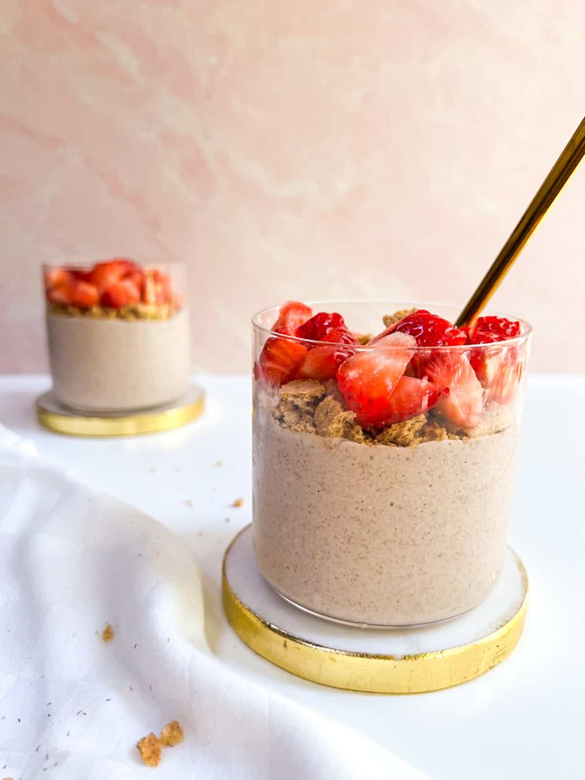 Strawberry overnight oats with a gold spoon.