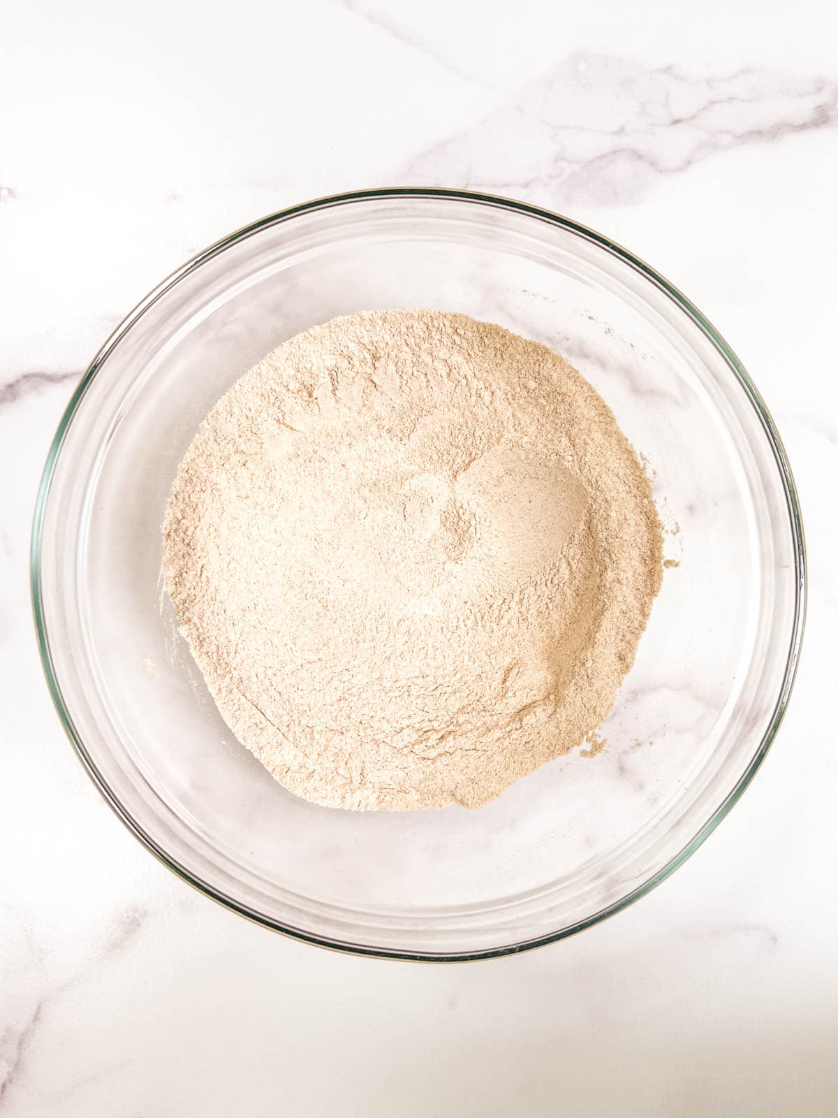 A bowl of dry ingredients sitting on a marble counter.