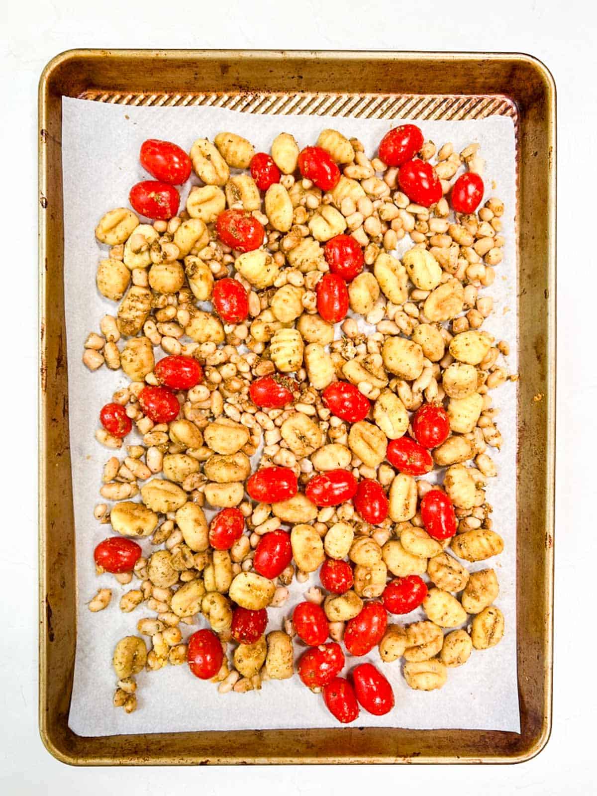 A sheet pan filled with gnocchi and tomatoes.