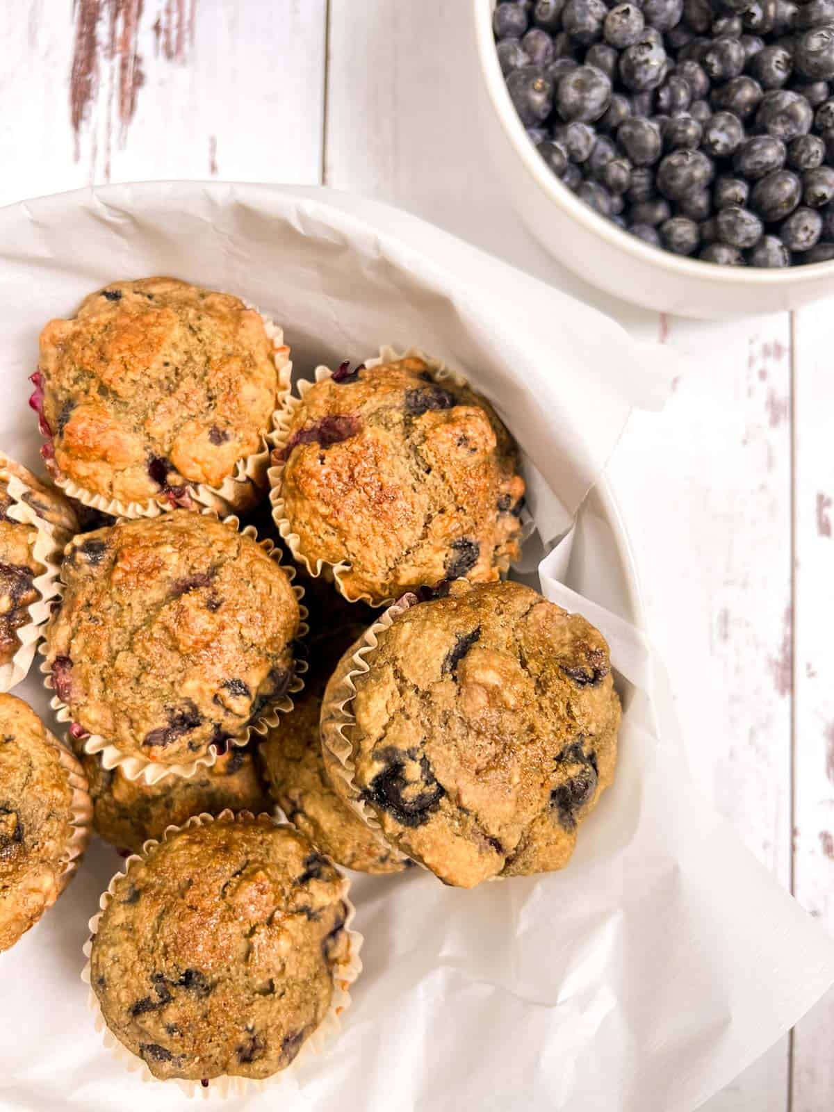Blueberry muffins in a white bowl.